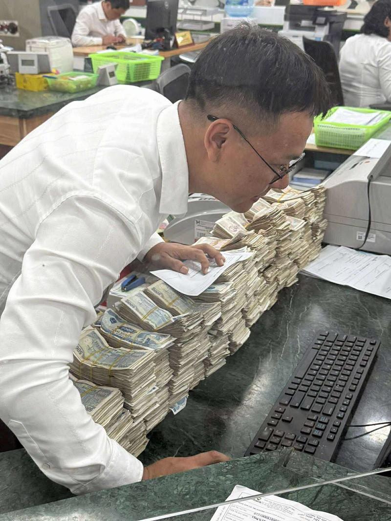 Cán bộ ngân hàng "toát mồ hôi hột" khi kiểm đếm số tiền 700 triệu đồng này. (Ảnh: Vương Đình Tú)