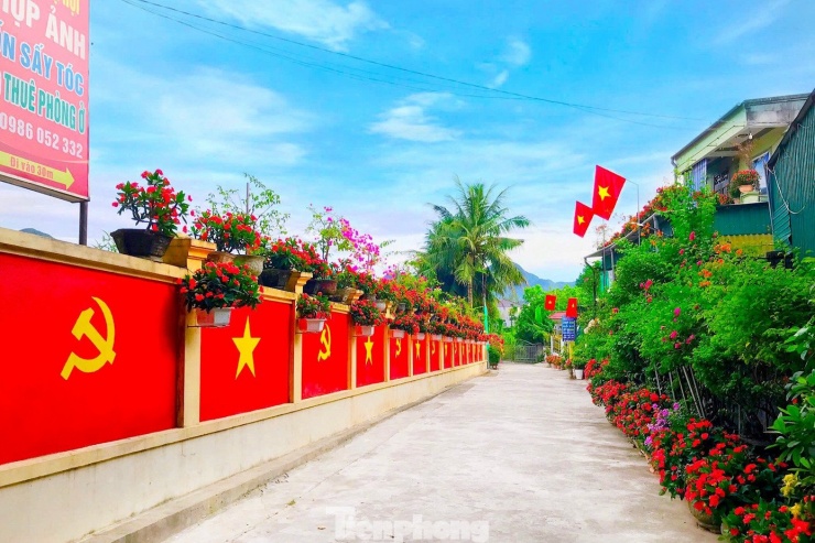 Con đường dài 40m rực rỡ cờ Tổ quốc, cờ Đảng do vợ chồng anh Trần Minh Tâm (SN 1972) và chị Phan Thị Minh Thụy (SN 1983), trú xã Tân Kỳ, tỉnh Nghệ An thực hiện. Anh chị đã dành nhiều ngày để khoác lên bờ tường trước nhà “tấm áo mới”.