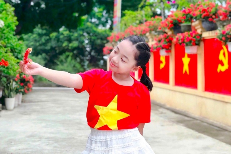 Em nhỏ trong màu áo đỏ sao vàng.