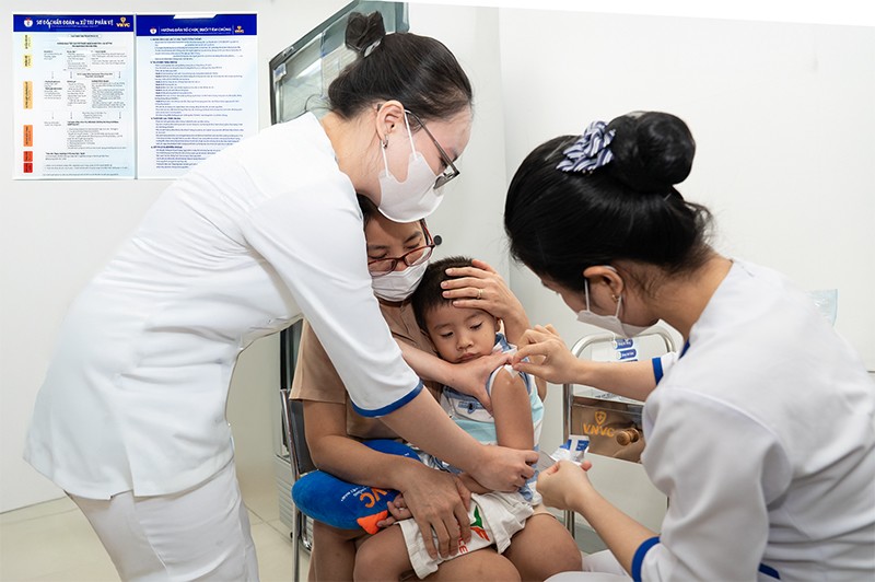 Phụ huynh đưa trẻ đi tiêm vắc xin não mô cầu mới tại Hệ thống Tiêm chủng VNVC sáng 15/8. Ảnh: Mộc Thảo