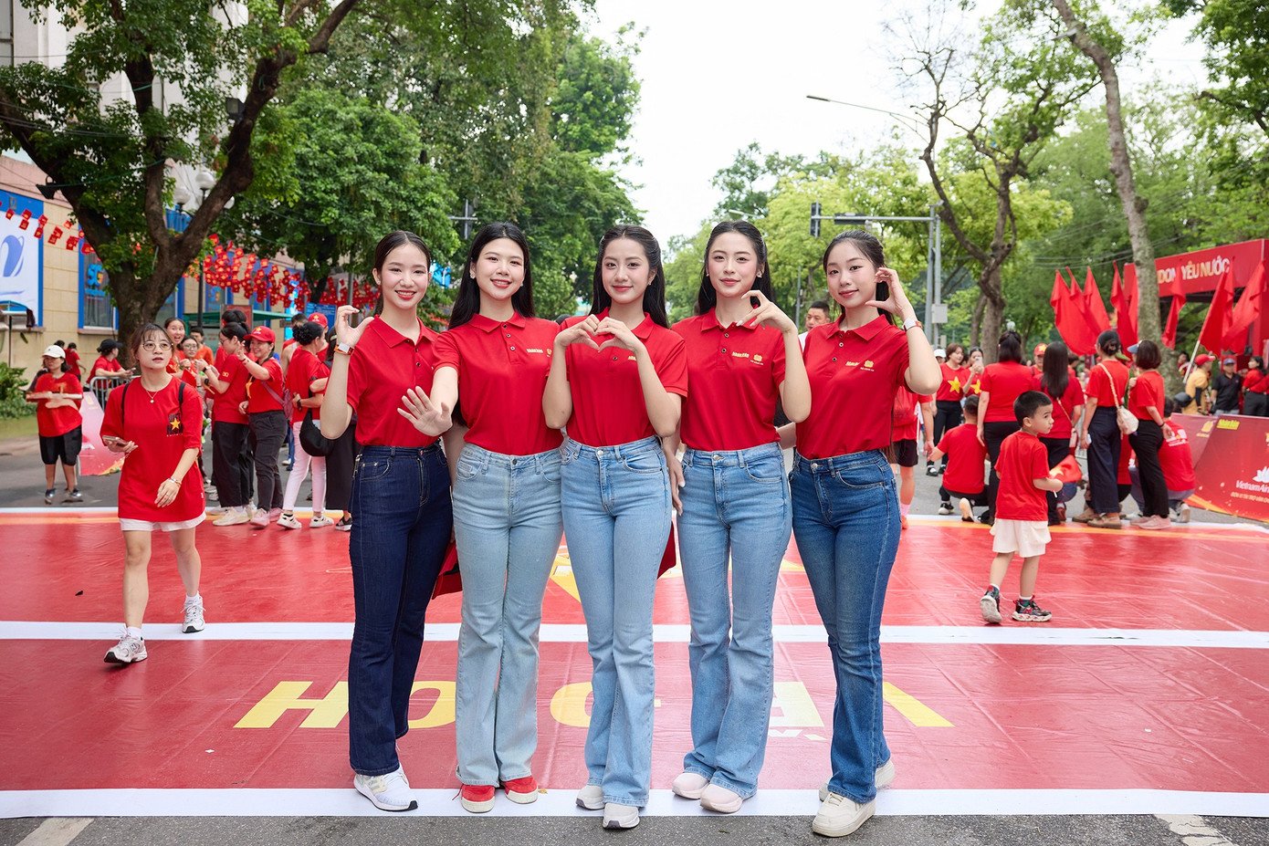 Các người đẹp chụp ảnh cùng lực lượng công an và người dân tham gia buổi đi bộ, chạy bộ.