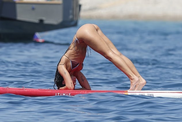 Cô cũng tập những động tác yoga khác, bao gồm tư thế chó úp mặt.