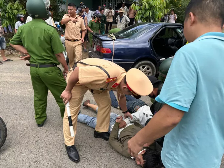 Công an khống chế 3 người cùng chiếc ô tô gắn biển số giả. Ảnh: VÕ TÙNG