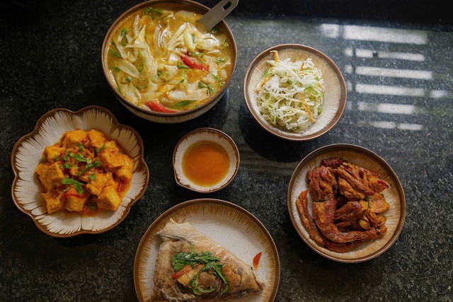 Món ăn ngon trong mâm cơm này có: Đầu cá nấu chua + đậu sốt cà chua + cá kho + canh chua + dưa muối.