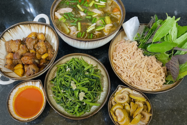 Món ăn ngon trong mâm cơm này có: Nem thính + rau muống xào tỏi + sườn xào chua ngọt + sung muối + canh sườn nấu chua.