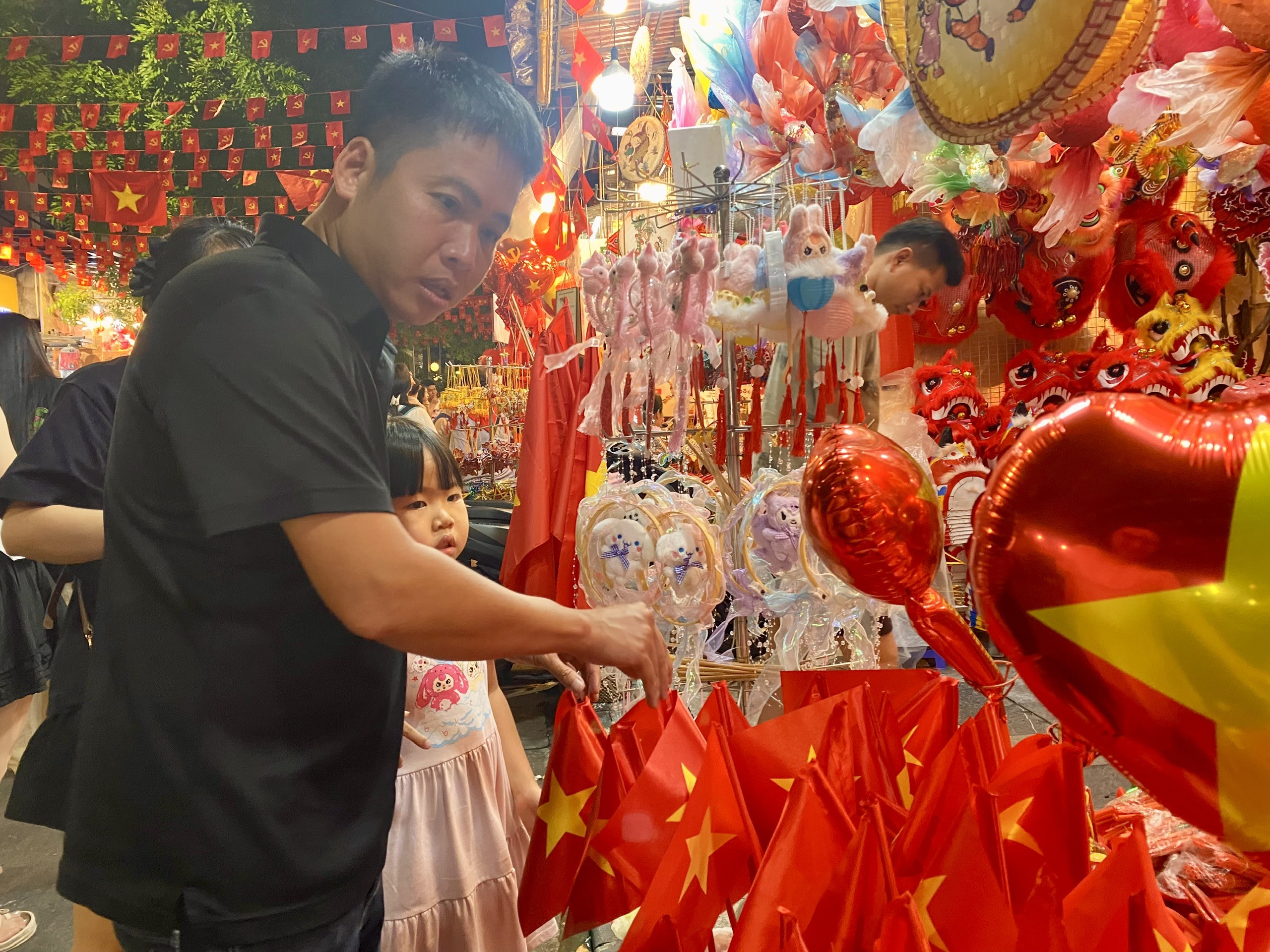 Khách hàng tấp nập chọn mua đồ trang trí như cờ Tổ quốc, lá cờ mini, băng rôn, băng đô, áo in hình Quốc kỳ, nón sao vàng, dây treo trang trí…