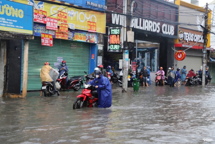 Nhiều người phải dừng chờ nước rút ở bên đường nên bị trễ giờ làm. Ảnh: Tuấn Kiệt.