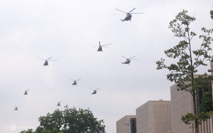 Bên dưới, hàng trăm người dân ở khu vực quảng trường Ba Đình theo dõi, ghi lại hình ảnh trực thăng biểu diễn. Ảnh: Tuấn Tâm
