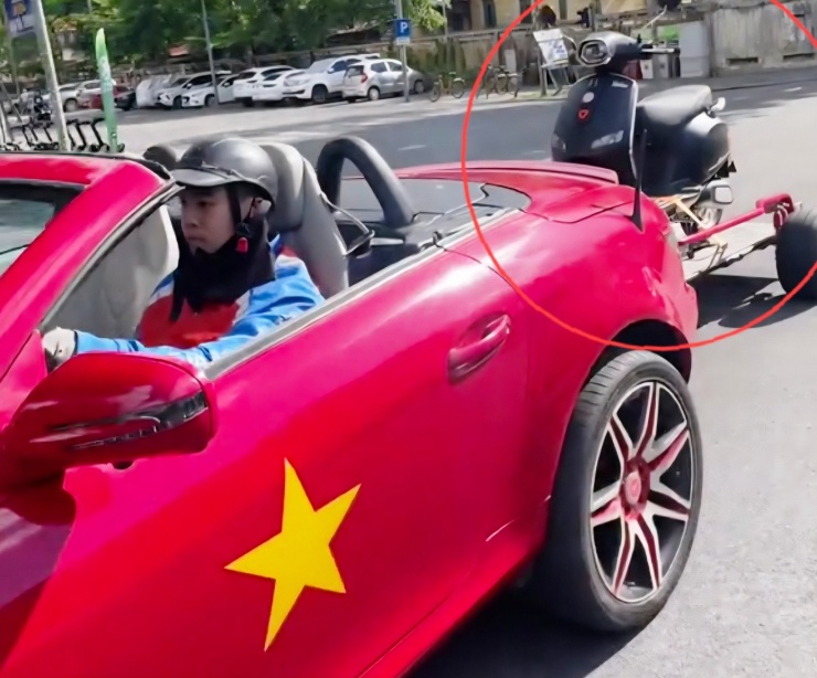 Tài xế Bùi Văn Hòa điều khiển xe mui trần Mercedes không thắt dây an toàn, kéo xe tự chế chở thêm xe máy điện phía sau. Ảnh cắt từ clip