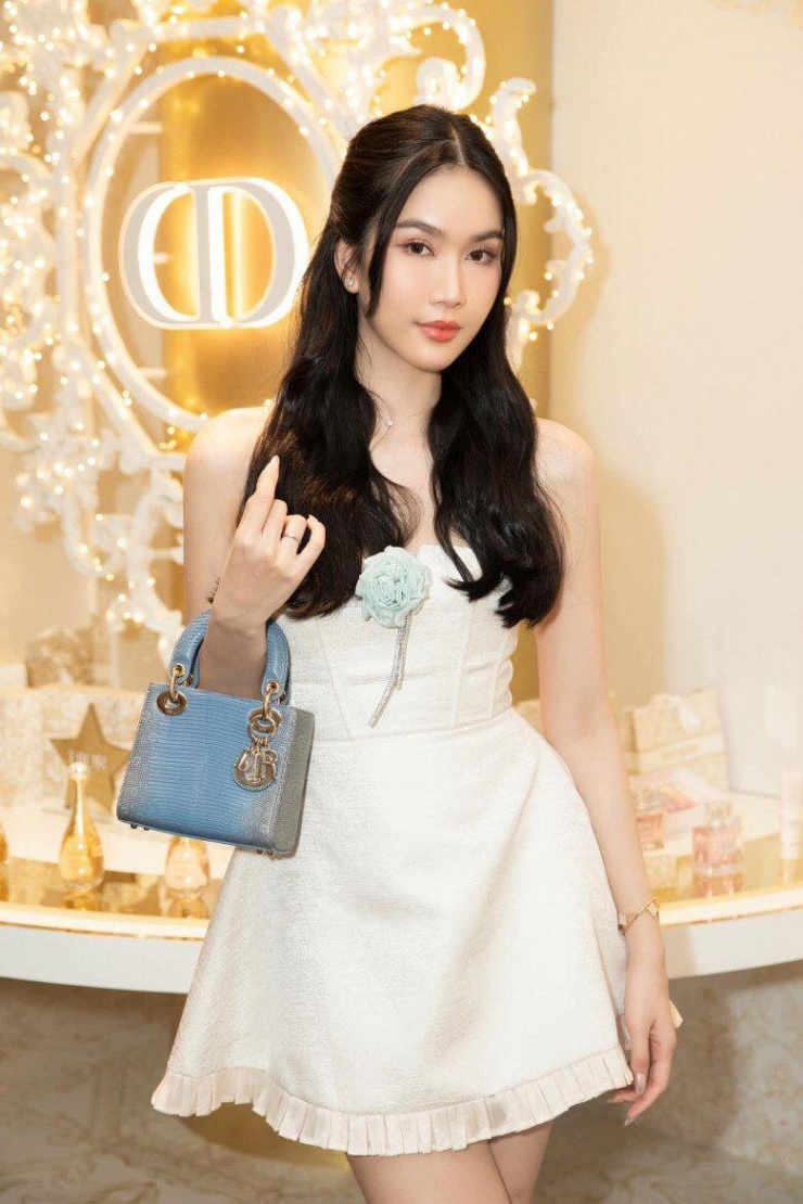 Một chiếc túi xách khác cùng thương hiệu cũng được nàng hậu trưng dụng với váy trắng ngắn nữ tính, điệu đà.