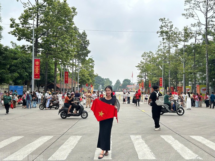 Người dân đứng ở đầu đường Hùng Vương để chờ xem tổng hợp luyện diễu bin, diễu hành tối 21-8. Ảnh: Minh Chiến