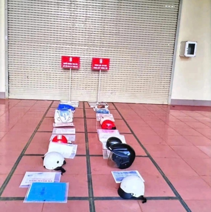 Người dân dùng mũ bảo hiểm, tài liệu "xếp hàng" chờ giải quyết thủ tục hành chính