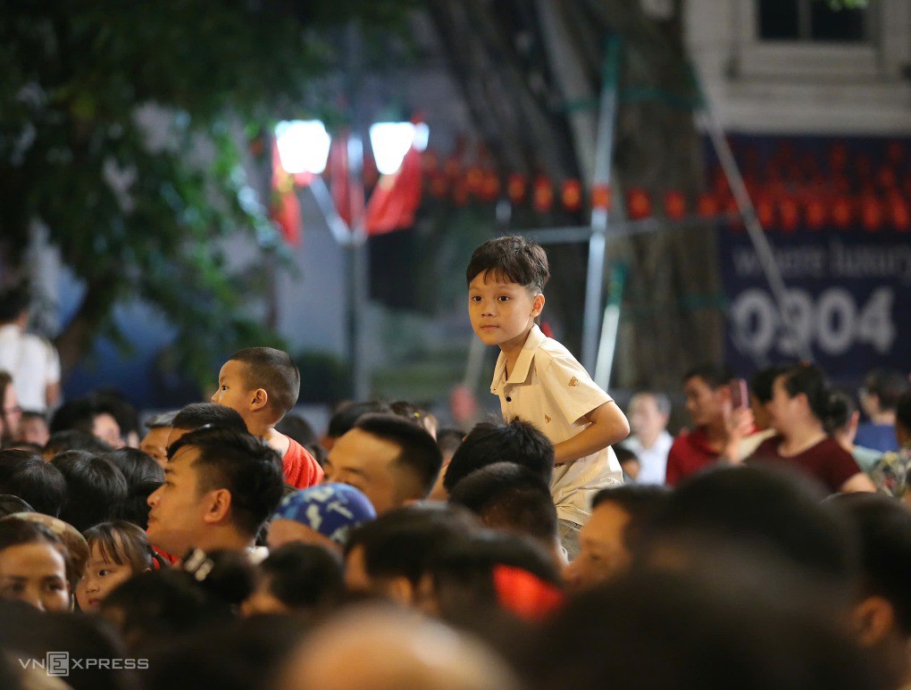 Các em nhỏ được bố mẹ kênh trên vai. Ảnh: Hiếu Lương