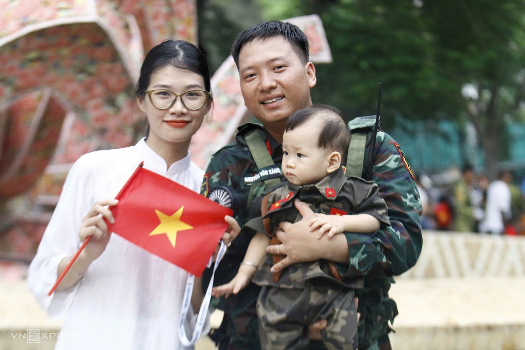 Anh Nguyễn Văn Sáng, chiến sĩ pháo binh, tranh thủ ít phút gặp vợ con sau gần 5 tháng xa nhà. Chị Đỗ Thu Huyền, vợ anh, cho biết cho con trai gần một tuổi từ quê nhà Hải Phòng lên Thủ đô đón bố lúc 9h sáng nay. "Dù chỉ được gặp ít phút ngắn ngủi, cả nhà tôi rất vui", chị nói. Ảnh: Thanh Hằng