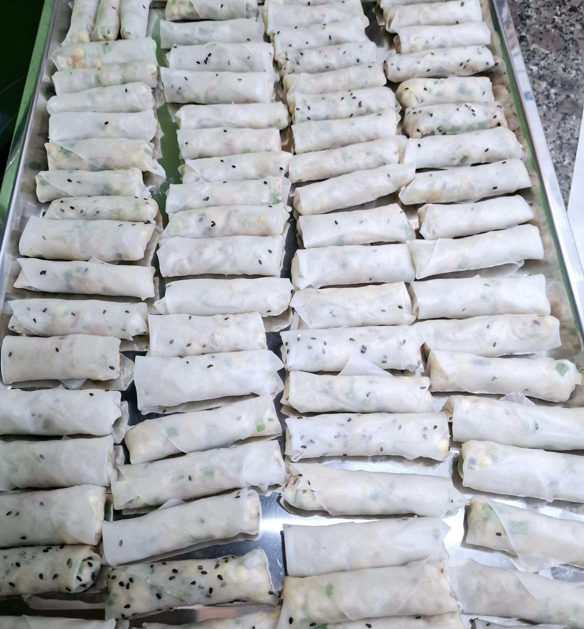 Ram bắp dùng bánh tráng mè rất thơm và giòn. Nhúng qua bánh tráng vào nước rồi cuốn từng chiếc ram đều nhau.