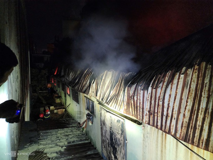 Cảnh sát cứu hỏa tiếp cận bên hông nhà xưởng để dập lửa. Ảnh: Đình Văn