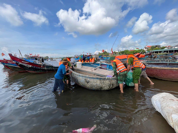 Cán bộ, chiến sĩ Biên phòng hỗ trợ đưa thuyền vào bờ tránh trú bão số 5