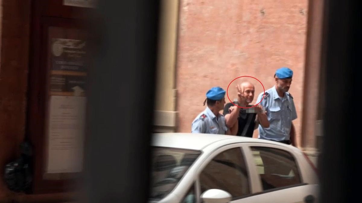 Serhii Kuznetsov làm dấu tay hình cây đinh ba (biểu tượng trên quốc huy Ukraine) khi bị đưa ra tòa án ở Italia (ảnh: ANSA)