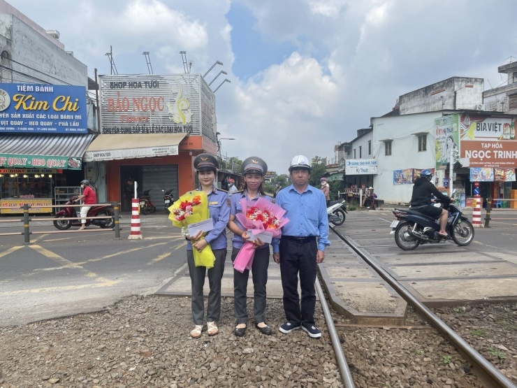 Đại diện CTCP đường sắt Sài Gòn khen thưởng 2 nhân viên gác chắn. Ảnh: A.X