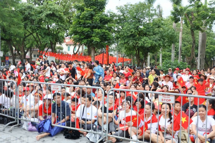 Hàng ngàn người ngồi chật kín các tuyến đường, vỉa hè, nơi sẽ có các đoàn diễn binh đi qua