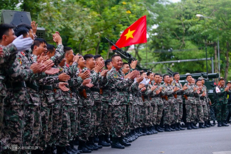 Trong lúc chờ di chuyển vào quảng trường Ba Đình, các chiến sĩ Tăng thiết giáp, Thông tin liên lạc giao lưu cùng người dân trên đường Thanh Niên, cùng nhau hòa giọng trong liên khúc Vì nhân dân quên mình, Như có Bác trong ngày đại thắng, Năm anh em trên chiếc xe tăng trong sự cổ vũ của người dân. Ảnh: Phạm Dự