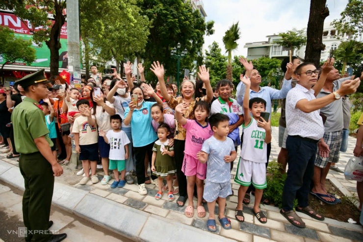 Người dân vẫy tay hò reo, cùng hát Như có Bác trong ngày đại thắng" (nhạc sĩ Phạm Tuyên) cổ vũ đoàn xe đi qua. Ảnh: Hiếu Lương