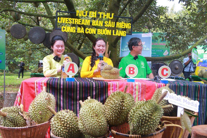 Bà Ngô Thị Minh Trinh (giữa), Bí thư Đảng ủy xã Ea Knuếc, cùng bà con buôn làng livestream bán sầu riêng ngay tại vườn