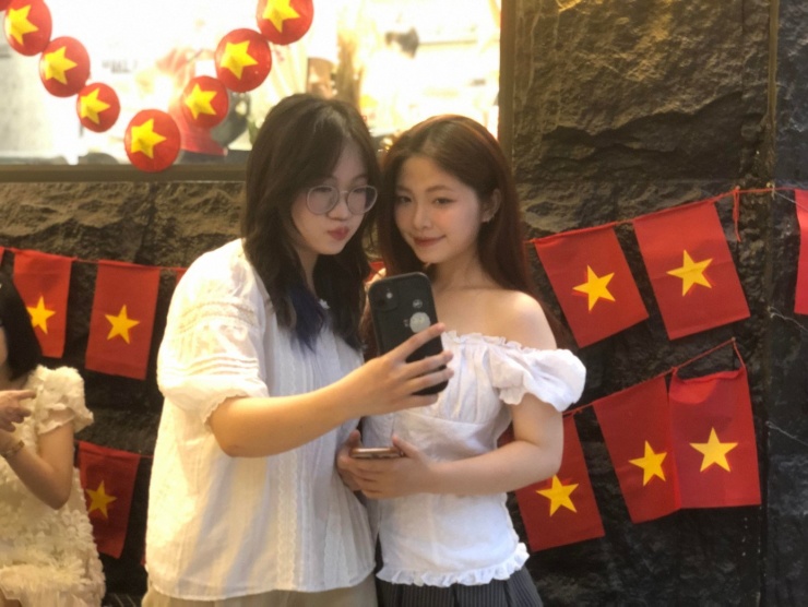 Hai bạn Huyền Thư và Ngọc Minh hào hứng check in chụp ảnh với không gian cờ hoa rực rỡ. Ảnh: Minh Vy