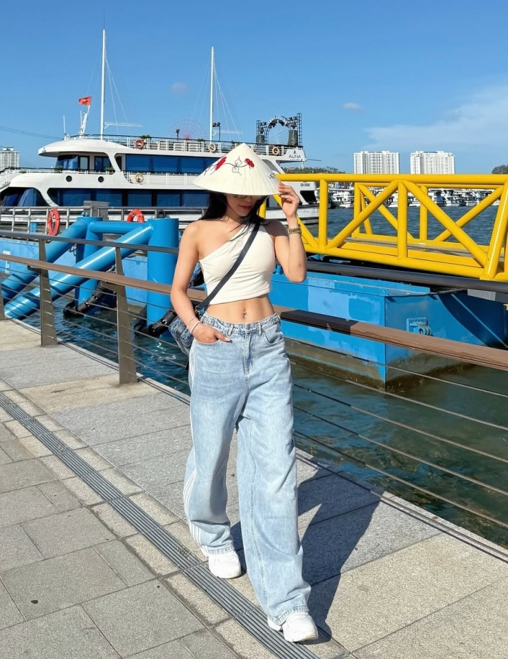Trong chuyến đi Hạ Long tháng 6, Diệp Lâm Anh tôn eo nhờ kết hợp áo lệch vai dáng ngắn cùng quần cạp cao.