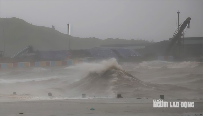 Cột sóng như bức tường trắng xóa tràn qua bờ kè cảng Hòn La trong chiều tối 25-8.