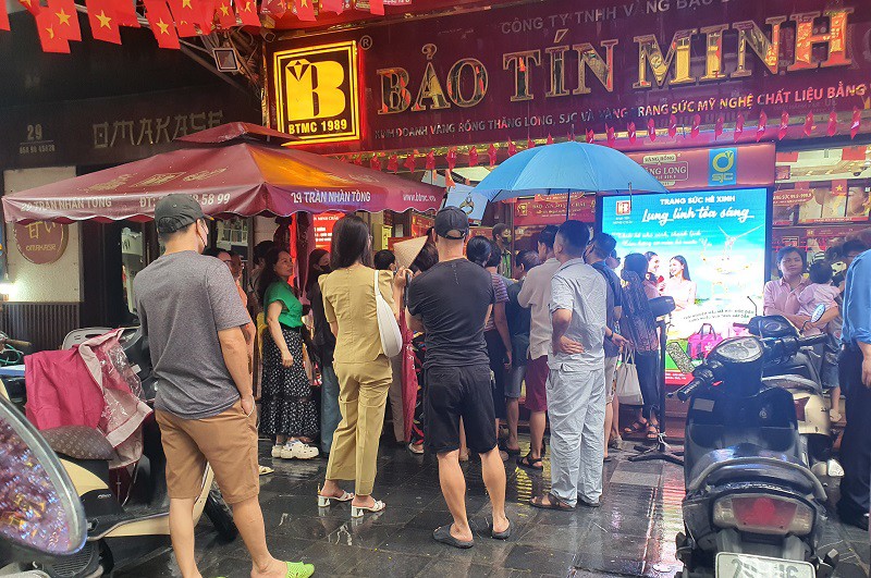 Nhiều người đội mưa xếp hàng mua vàng trong sáng nay.