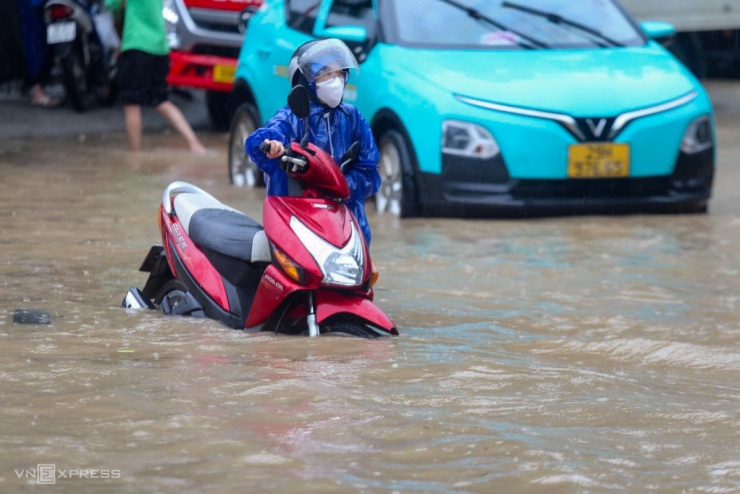 Tại quốc lộ 6 hiện giao thông đã tê liệt, vị trí ngập sâu nhất đến gần một m, nhiều ôtô, xe máy chết máy đứng giữa dòng. Một số người gửi xe để lên đường sắt Hà Đông - Cát Linh đi làm. Ảnh: Gia Chính