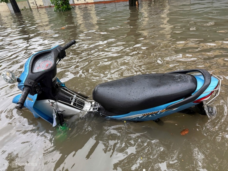 Nước ngập gần yên xe máy trên phố Trần Bình. Ảnh: Viết Tuân