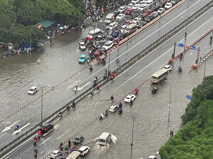 Dòng xe tê liệt ở Ngã tư Phạm Hùng - Xuân Thủy do một số đoạn ngập sâu. Ảnh: Lương Dương