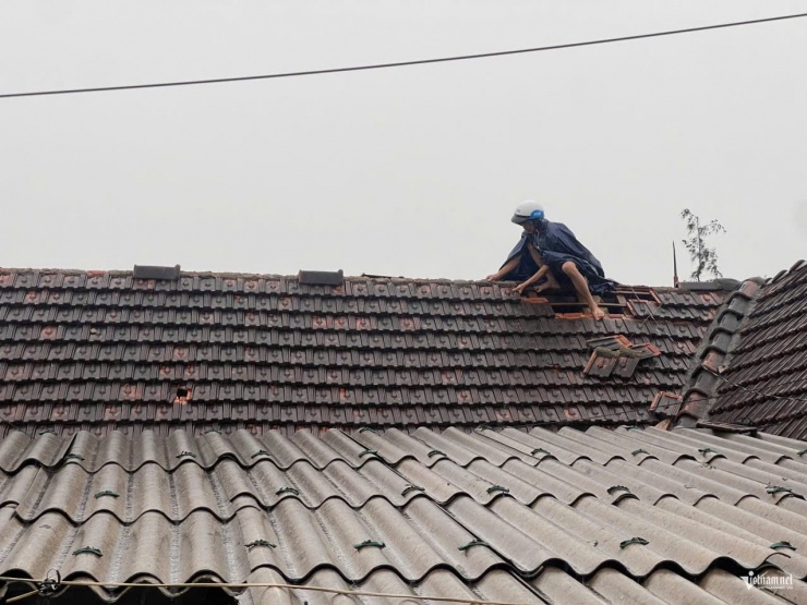 Người dân xã Thịnh Lộc trèo lên mái nhà gia cố sau bão.
