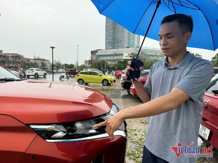 Một chủ xe bên chiếc bán tải bị vỡ đèn và kính cánh trái. Ảnh: K.N