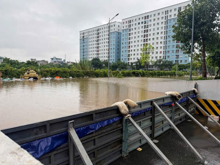 Hầm chung cư Ecohome 3, phường Đông Ngạc ngập hơn một mét, khiến ban quản lý chung cư phải làm đập ngăn nước vào hầm gửi xe sáng nay. Đập này dài khoảng 10 m, bằng thép, bên ngoài trải bạt để chống thấm. Ảnh: Viết Tuân