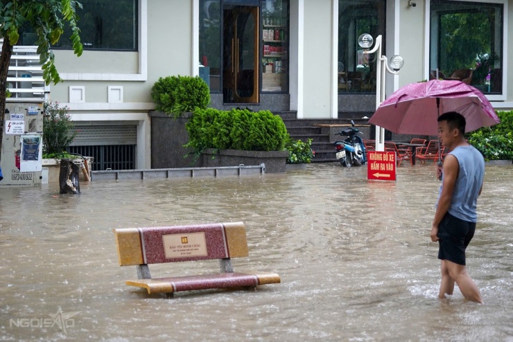 Cách đó gần 20 km, nhiều cửa hàng trên đường Hoàng Tùng, Hoài Đức, đã phải đắp rào chắn nước, cho máy bơm hoạt động liên tục. Ảnh: Lưu Quý