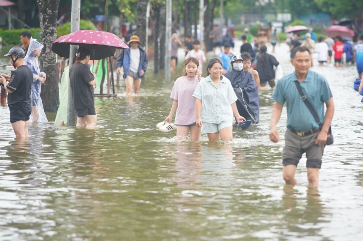 Giao thông khu vực trên tê liệt, người dân chỉ có thể đi bộ qua đoạn đường ngập.