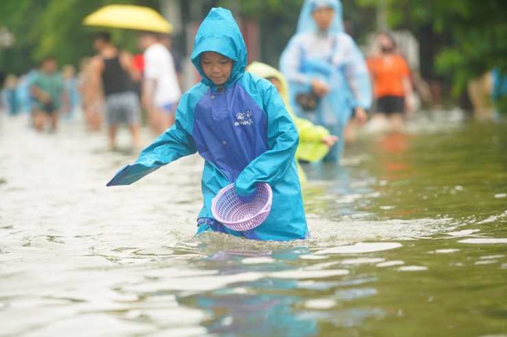 Đường và hồ &#39;hòa làm một&#39; sau mưa lớn, người dân lấy cọc làm mốc để lội về nhà - 13
