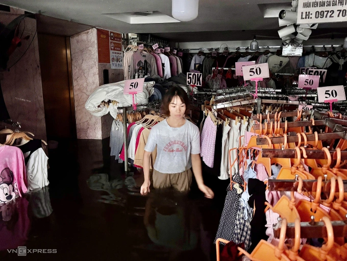 Chị Hồng Thị Xua, người bán hàng cho biết nước ngập lên quá nhanh từ sáng sớm nên tất cả hàng hoá, xe cộ không kịp di chuyển. Ảnh: Anh Phú