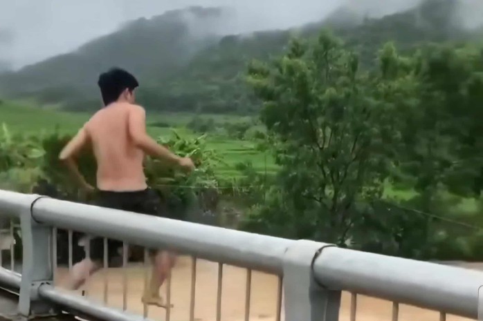 Người đàn ông bất ngờ trèo lan can cầu, lao xuống dòng nước lũ - Ảnh chụp màn hình