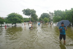 Tin tức trong ngày - Đường và hồ 'hòa làm một' sau mưa lớn, người dân lấy cọc làm mốc để lội về nhà