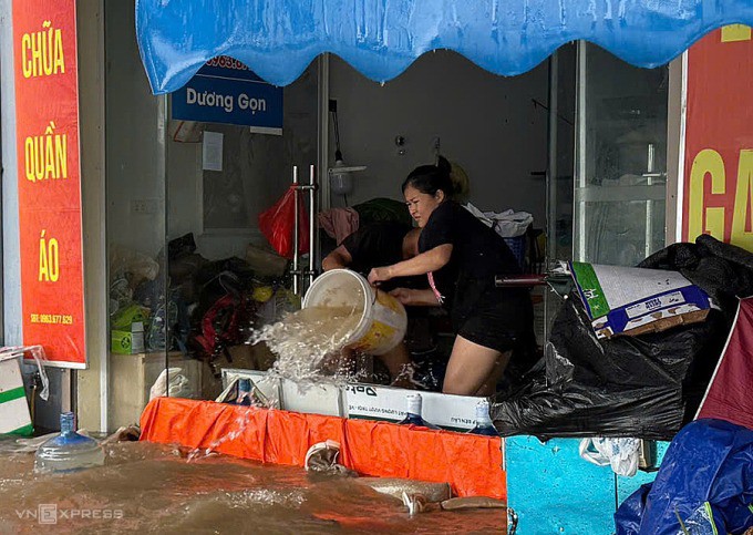 Người dân tát nước ra ngoài. Ảnh: Viết Tuân