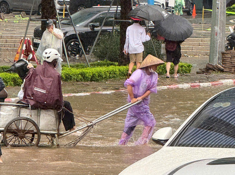 Dịch vụ kéo xe bò qua đoạn ngập cũng xuất hiện tại tuyến phố này. (Ảnh: Thành Thái)