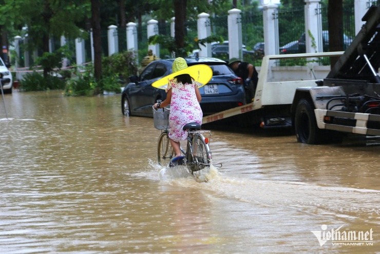Người dân chủ động rọn rác tại các nắp cống thoát nước để khơi thông dòng chảy. Ảnh: Phạm Công
