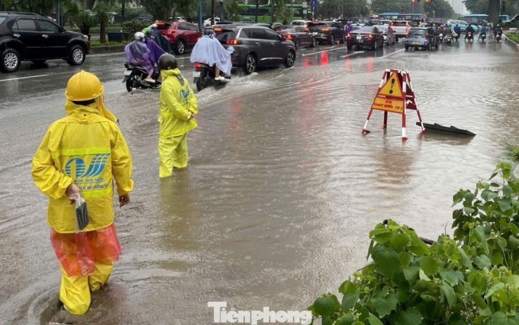 Tại các vị trí ngập sáng 27/8, nhân viên Công ty Thoát nước vừa dựng biển cảnh báo vừa đứng điều tiết xe không đi vào vùng bị ngập nặng.