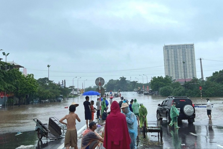 Dịch vụ đưa người và phương tiện qua đoạn ngập ở đầu cầu Tây Mỗ sang đường 70 Xuân Phương - Xuân Canh. Ảnh: Lê Quỳnh.
