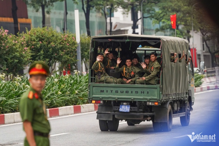Các chiến sĩ vẫy chào, thả tim với người dân trên đường hành quân. Ảnh: Trần Minh Quân