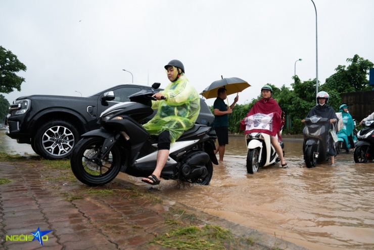 Các phương tiện phải leo vỉa hè, đi qua đoạn bùn đất để tránh khu vực ngập sâu.